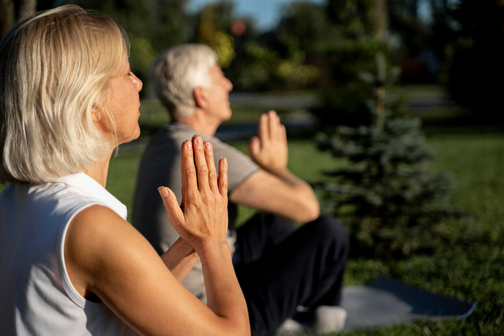 side-view-of-older-couple-practicing-yoga-outdoors.jpg